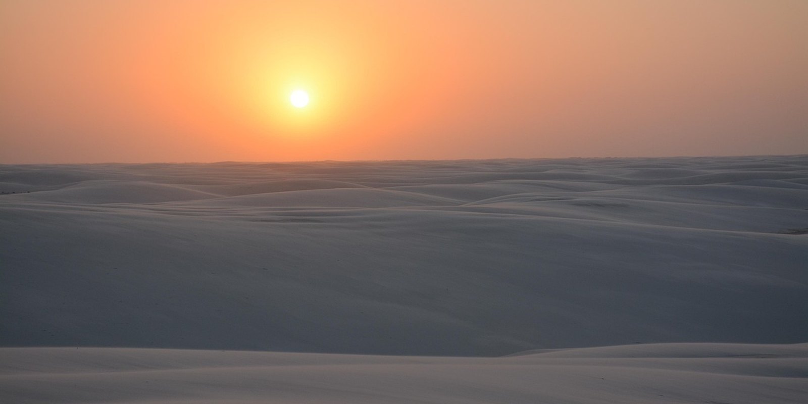 Pôr do sol dourado sobre as dunas dos Lençóis Maranhenses